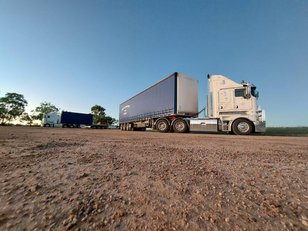 Two Semi Trucks Are Parked Next to Each Other on A Dirt Road — Smillie Transport Pty Ltd in Two Mile, QLD