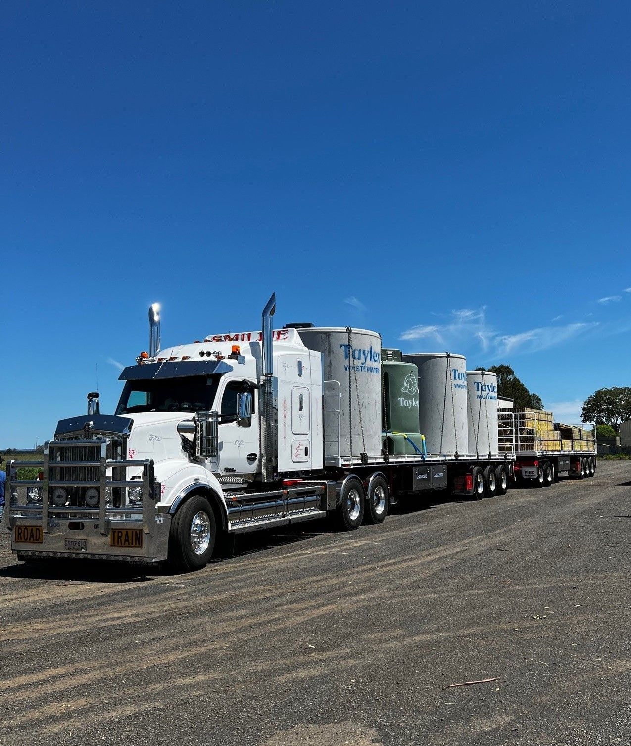 A Row of Semi Trucks Are Parked on The Side of A Road — Smillie Transport Pty Ltd in Two Mile, QLD