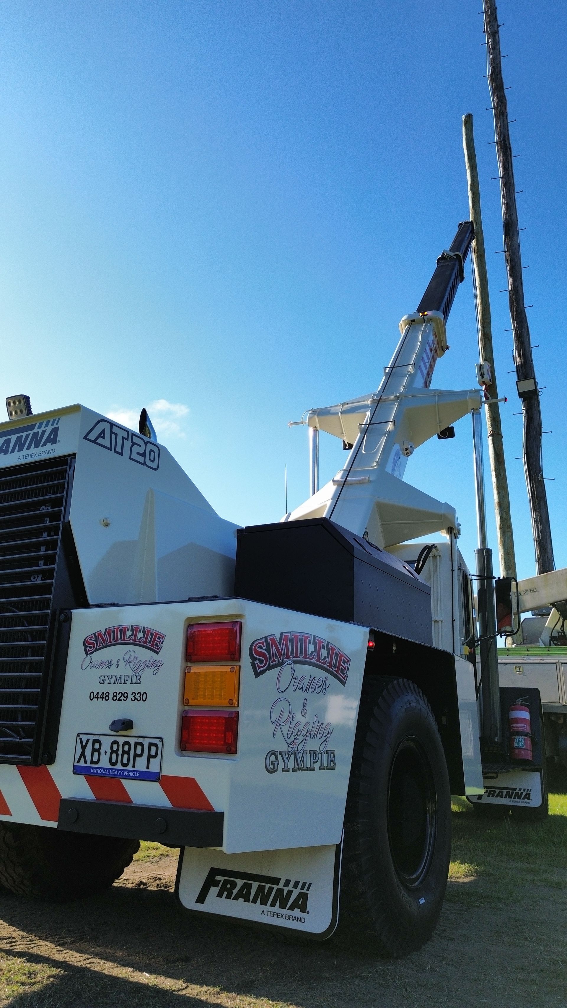Tow Truck With Raised White Crane Parked Outdoors — Smillie Transport Pty Ltd in Two Mile, QLD