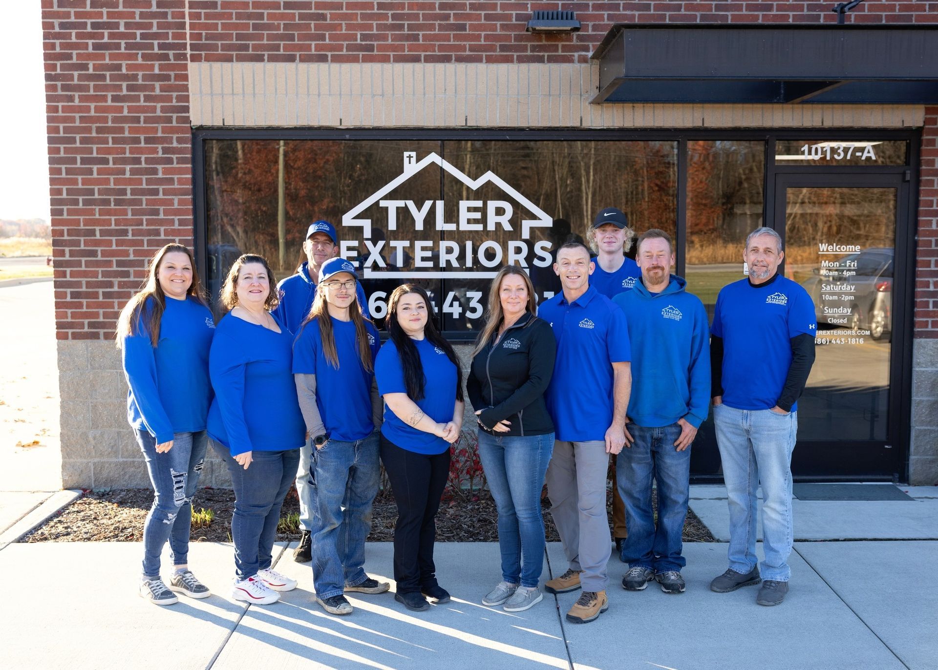 Group of people in blue shirts stand in front of 