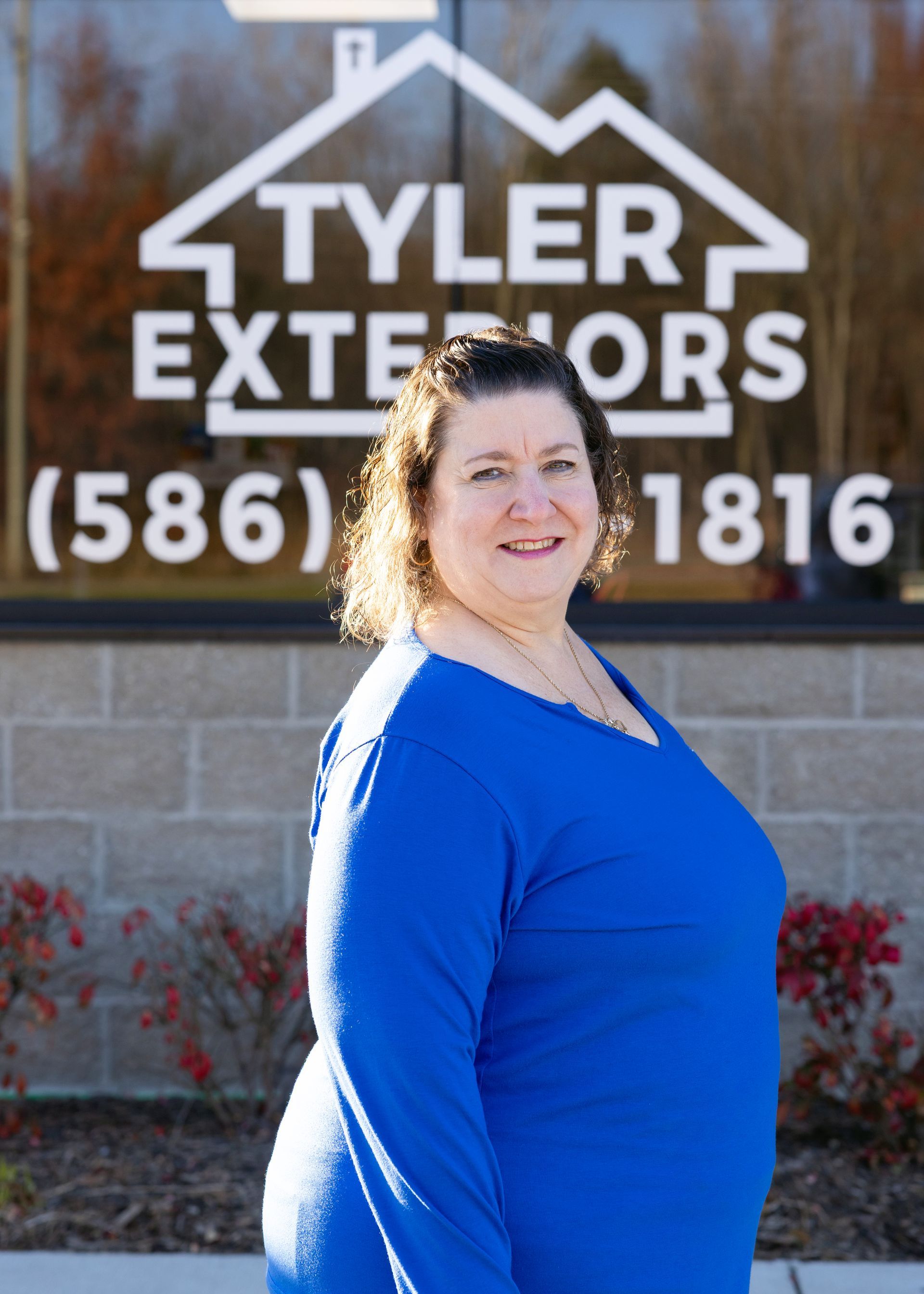 Woman in blue shirt smiling in front of 