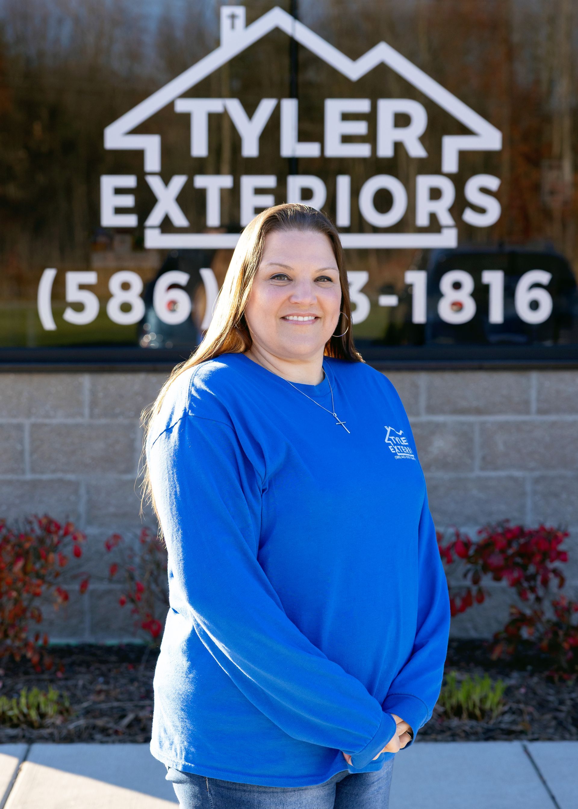 Woman in blue shirt smiling in front of 