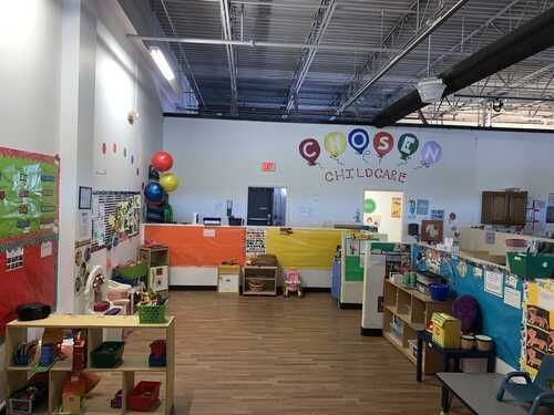 A classroom with a lot of toys and balloons on the wall.