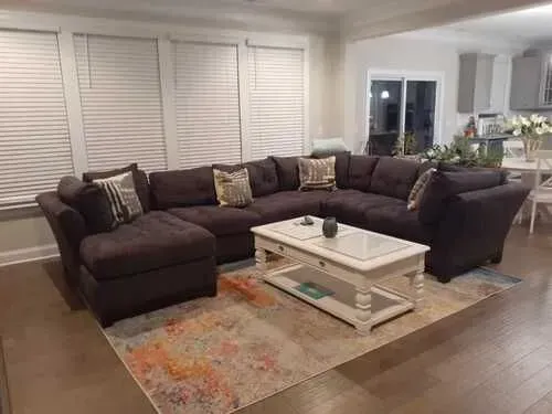 A living room with a large sectional couch and a coffee table.