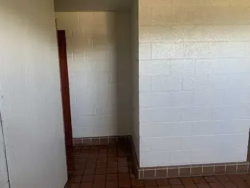 A room with a white brick wall and tile floor.