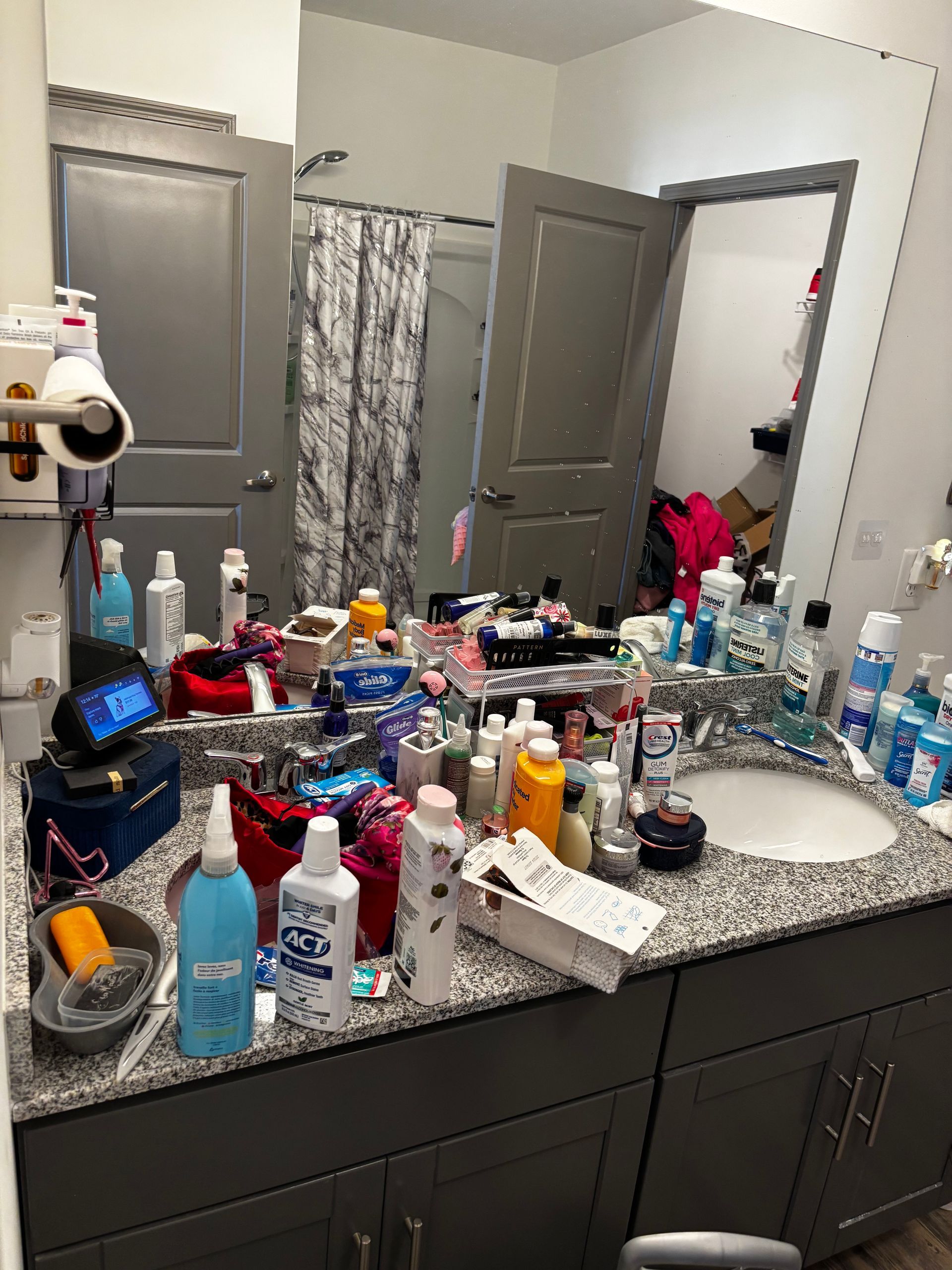 A bathroom with a sink and a mirror filled with lots of cosmetics.