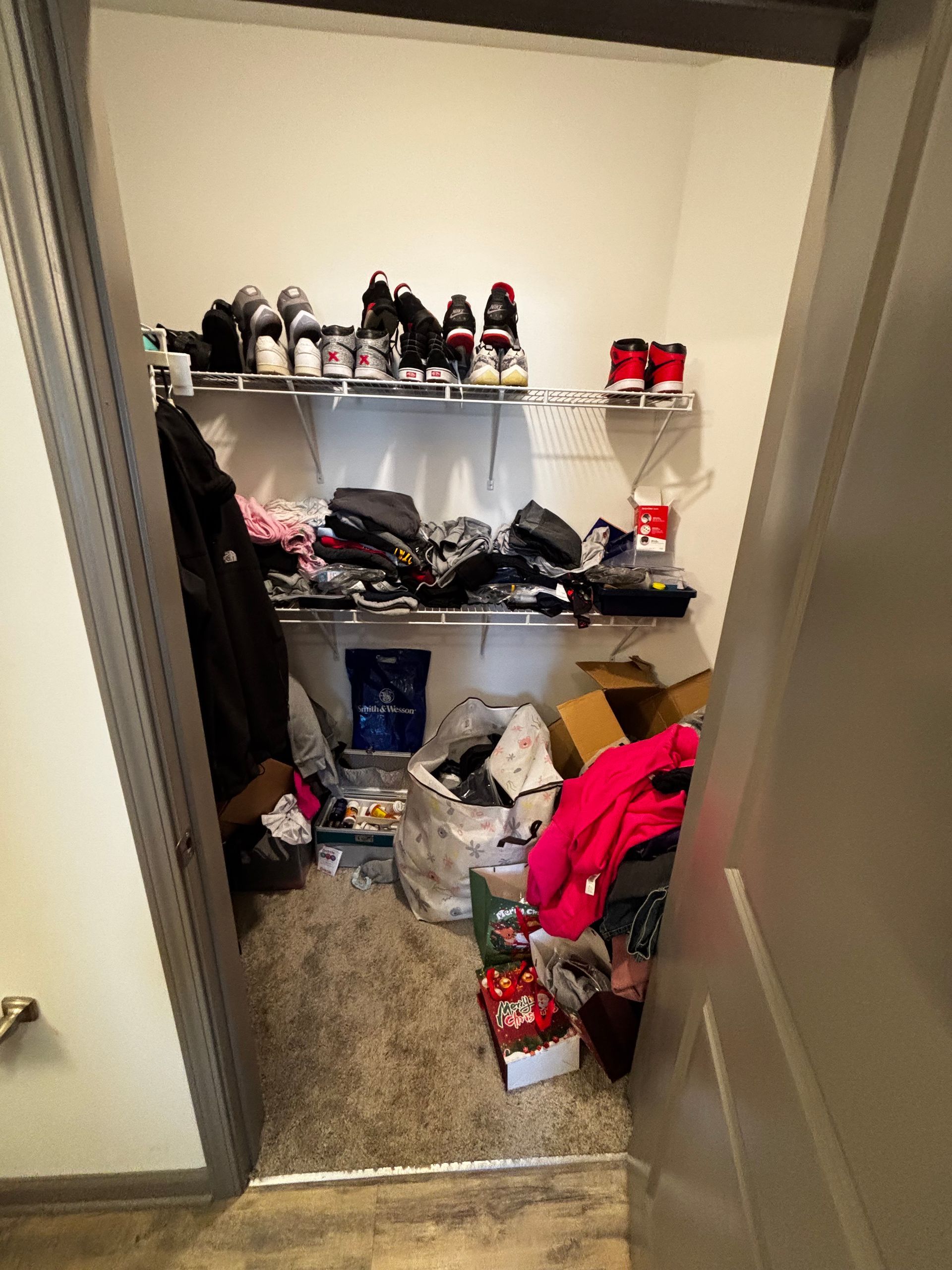 A closet filled with lots of clothes and shoes.