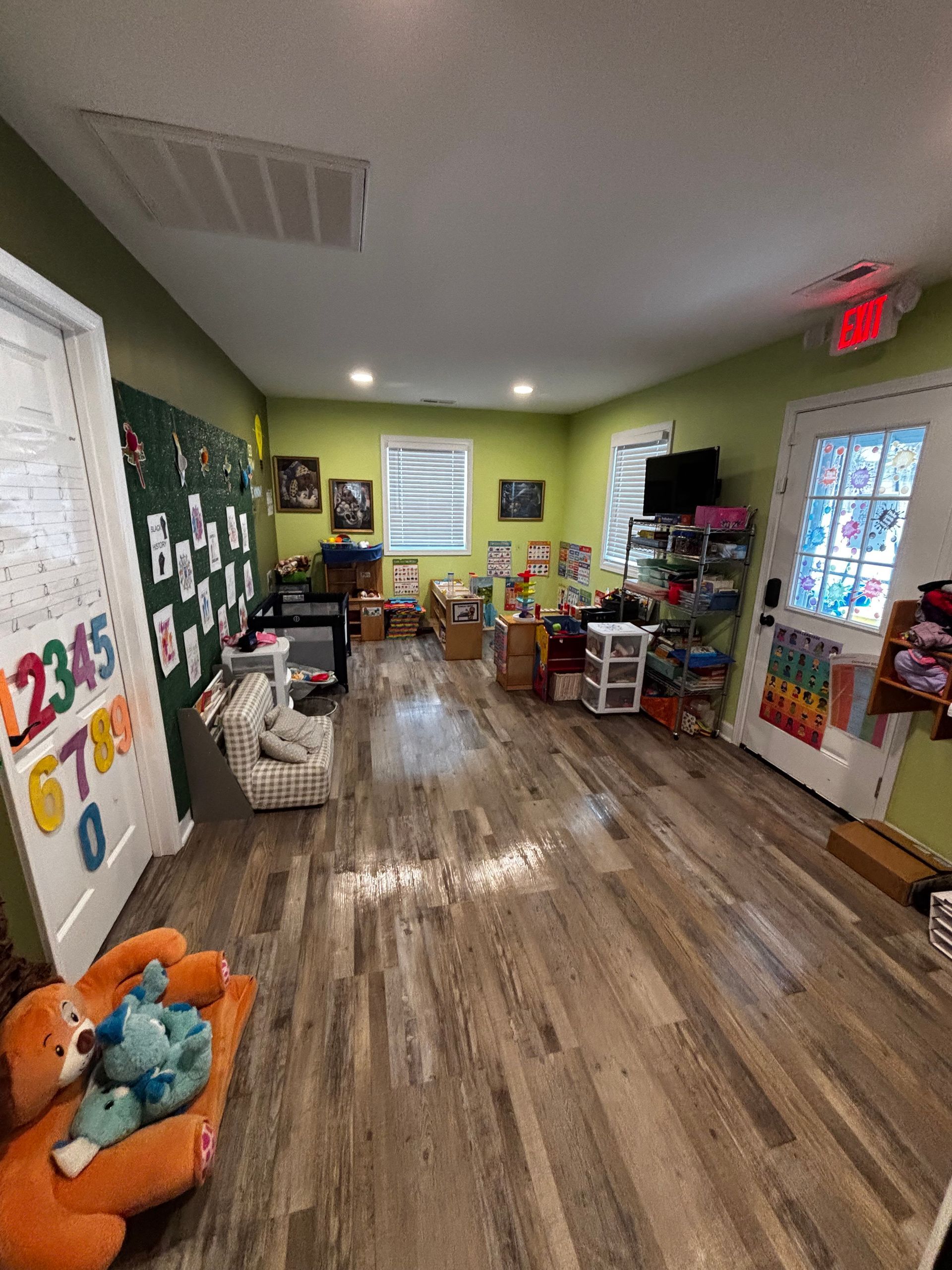 A large room filled with lots of toys and a teddy bear.