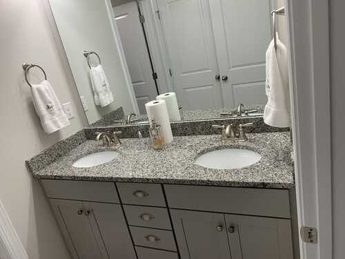 A bathroom with two sinks and a large mirror.