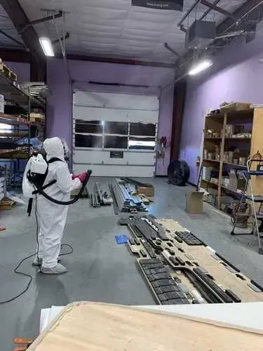 A man in a protective suit is disinfecting a building.