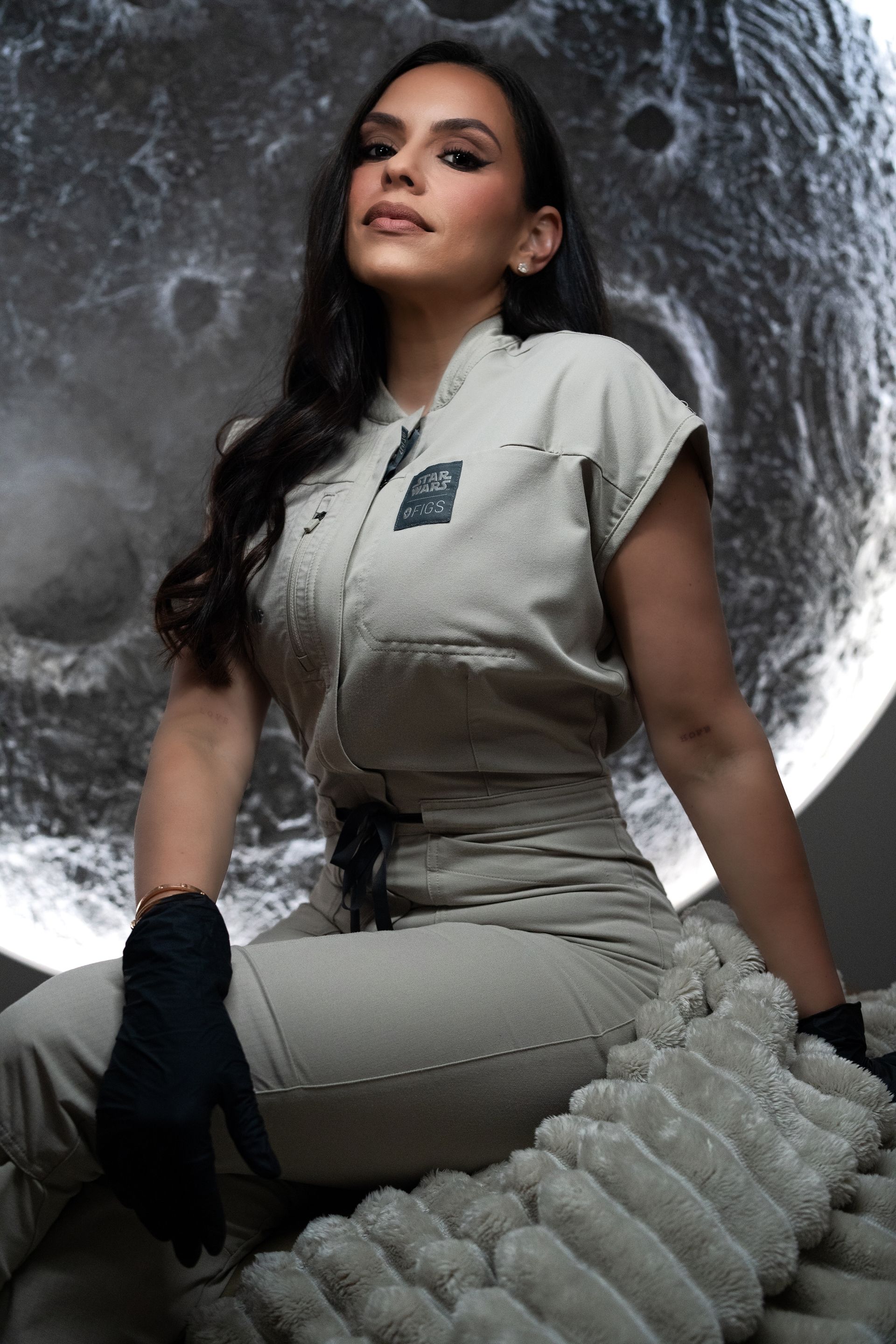 A woman in a white lab coat is holding a syringe.