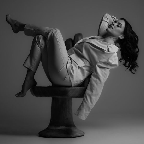 A woman is laying on a chair with her legs crossed.