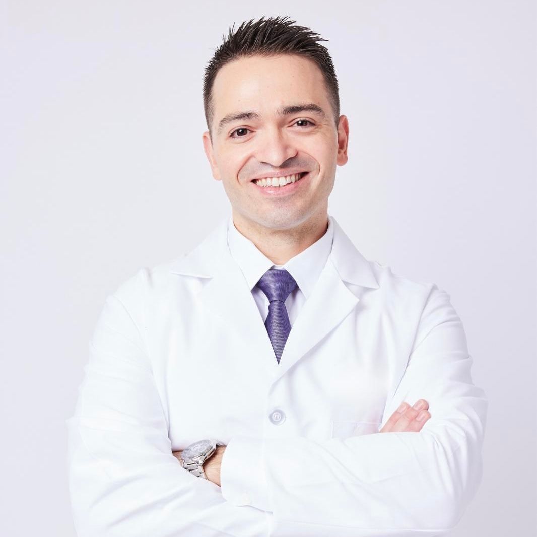A woman in a white coat is holding a syringe in her hand