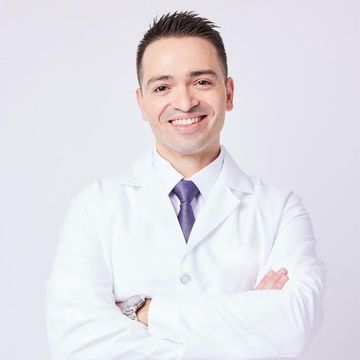 A woman in a white coat is holding a syringe in her hand