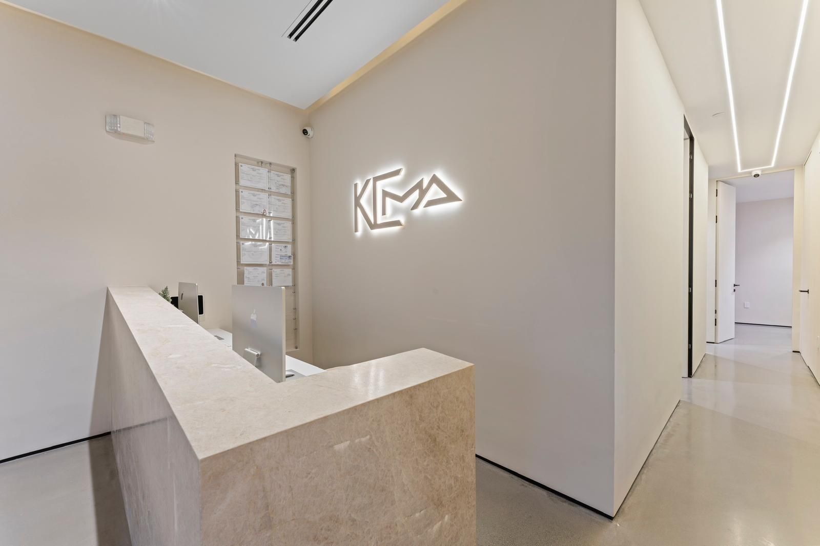 A dental office with a reception desk and a sign on the wall.