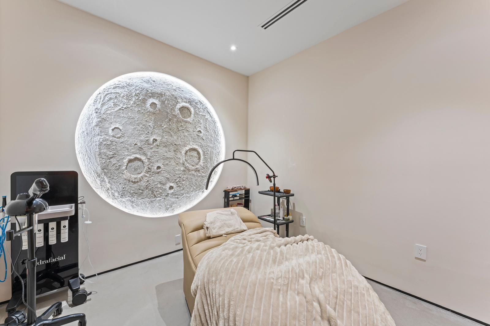 A room with a bed and a moon on the wall.