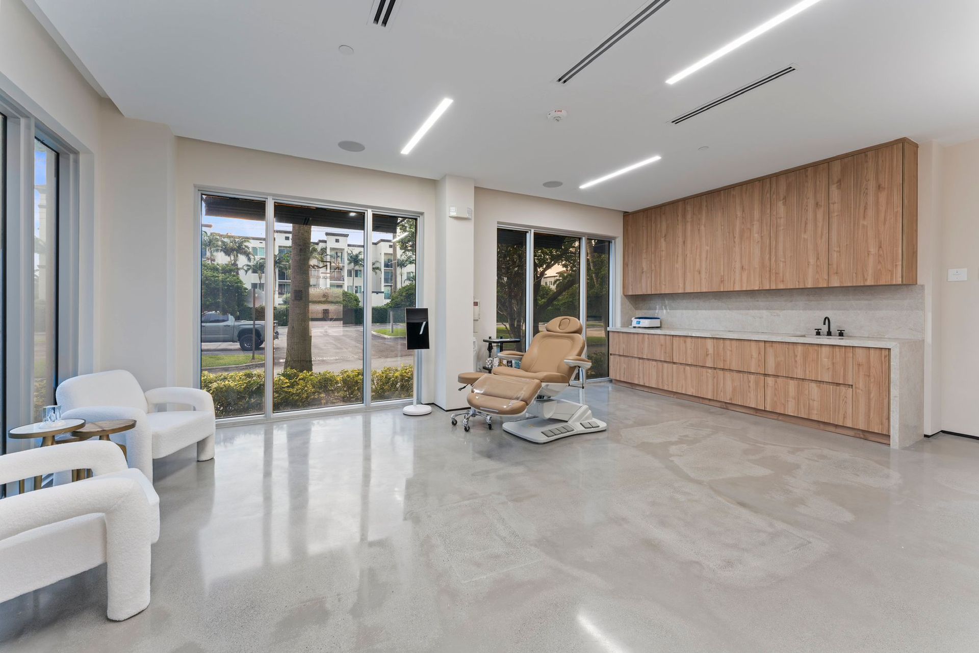 A large room with a dental chair and a lot of windows.