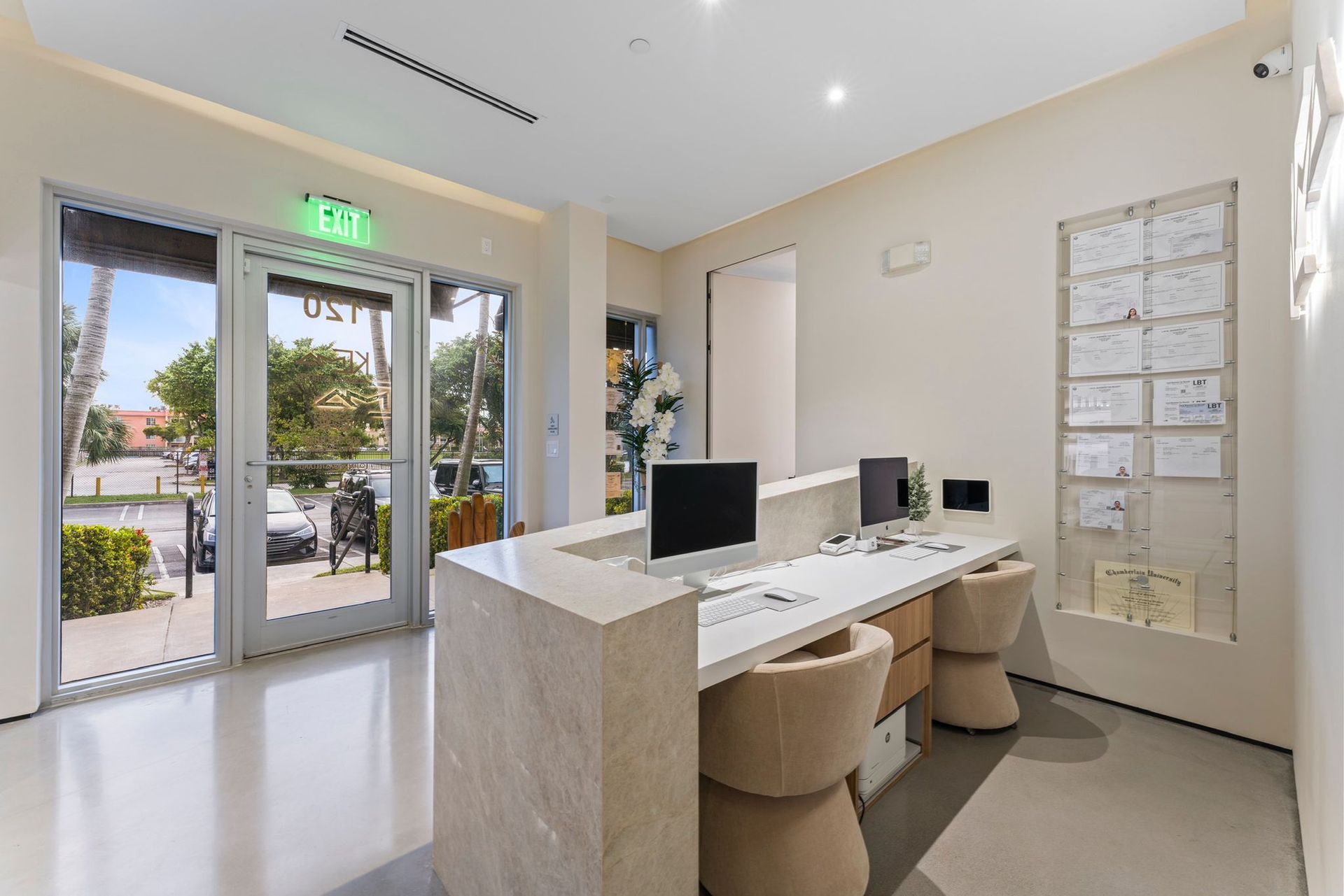 A room with a desk and chairs and a computer on it