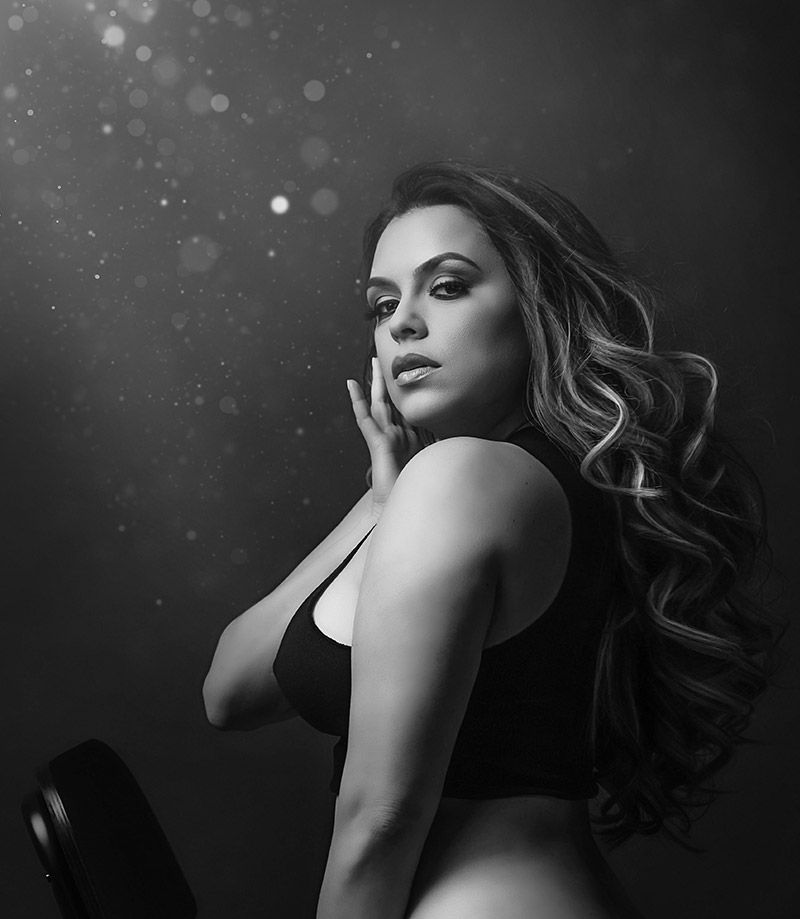 A black and white photo of a woman in a black bra