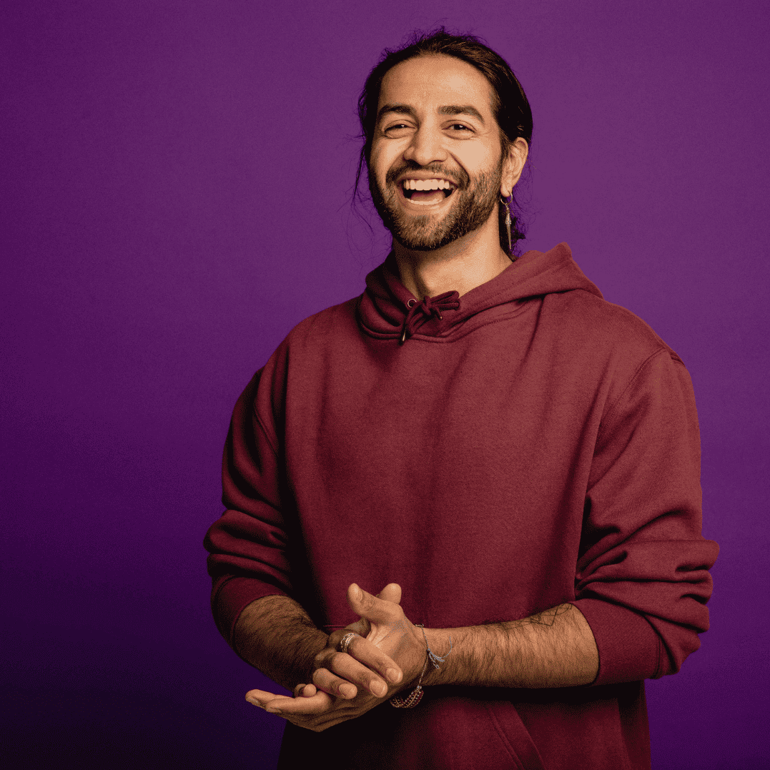 Data Engineering Recruitment specialists in a black hat and purple sweater, carrying a backpack against a purple background