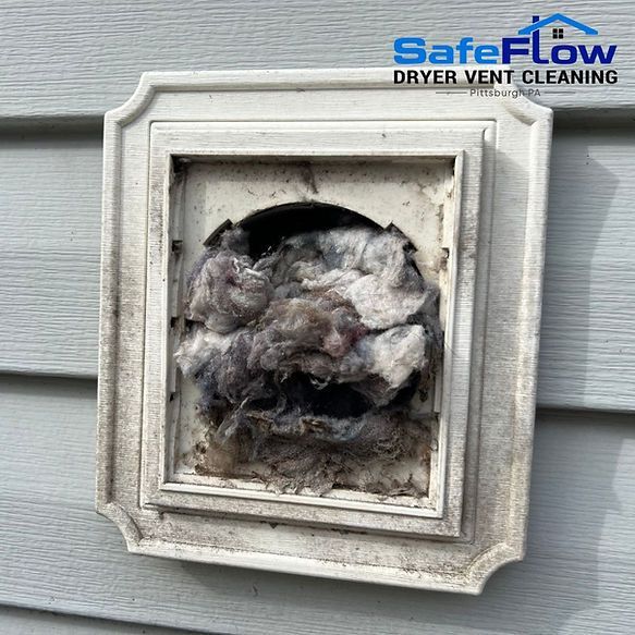 A picture of a dirty dryer vent on a house.