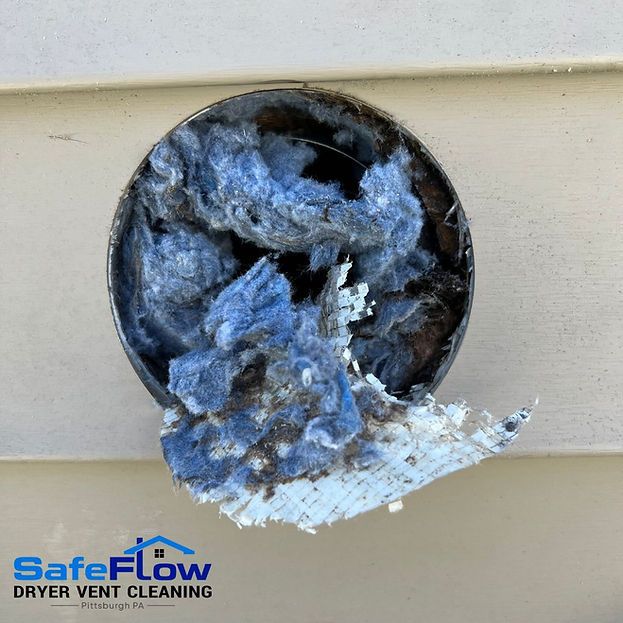 A dirty dryer vent with a safeflow dryer vent cleaning logo on it.