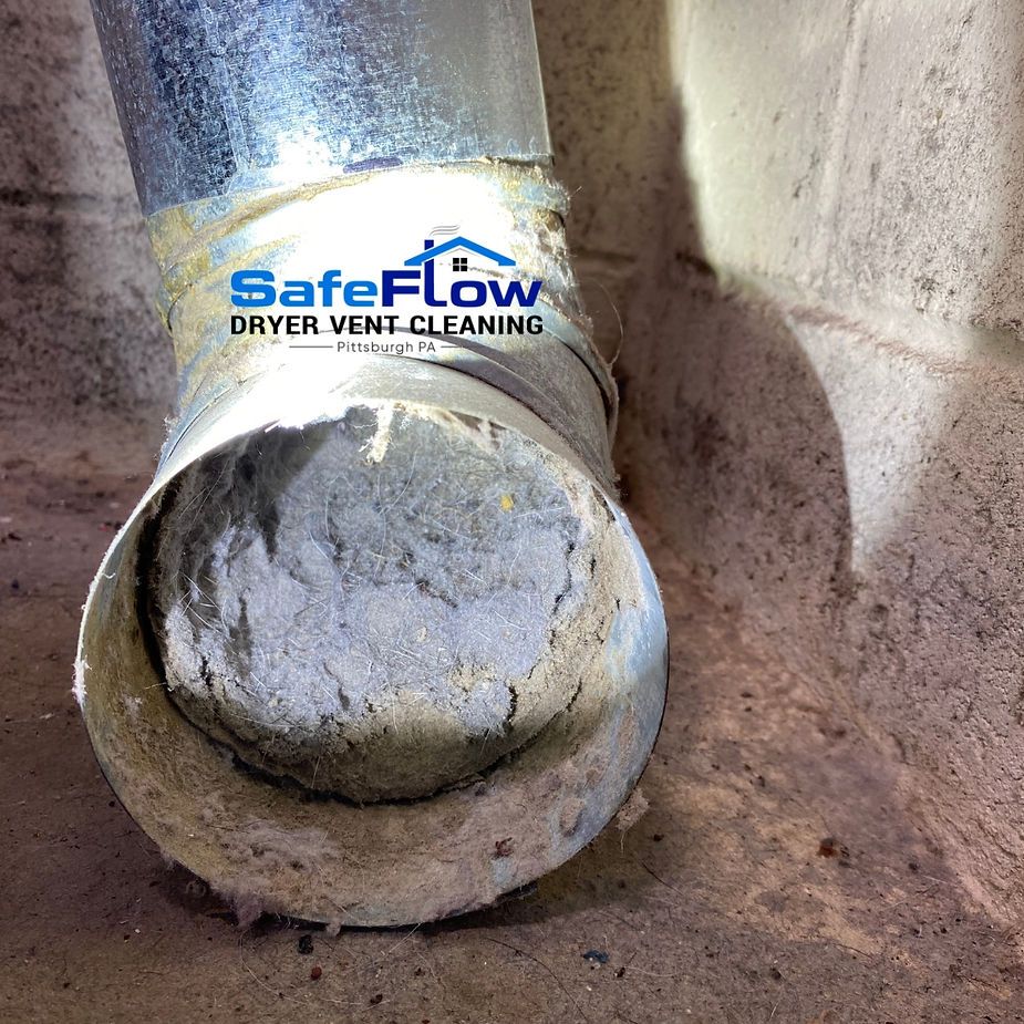 A close up of a dirty dryer vent with a safeflow dryer vent cleaning logo on it.