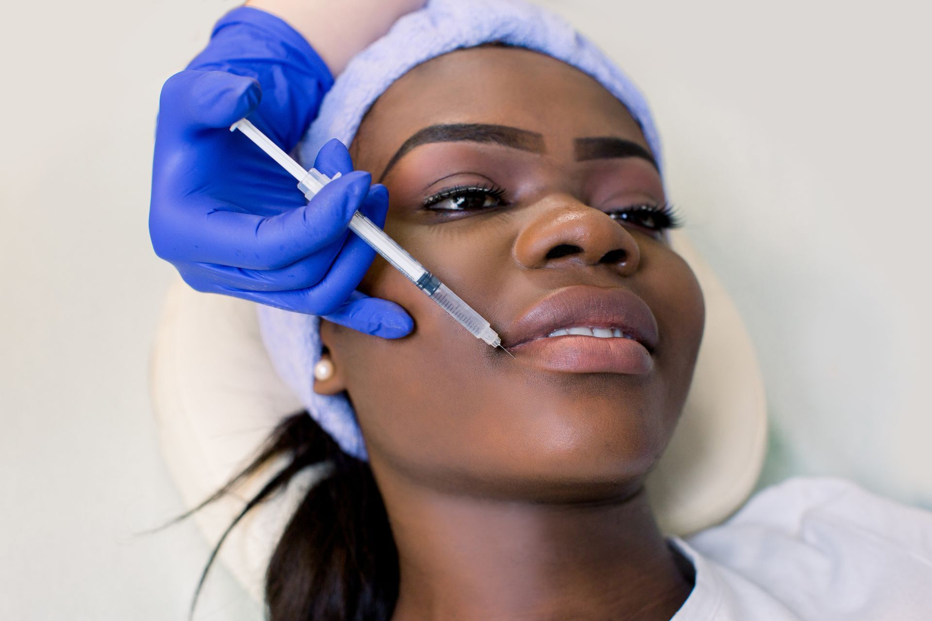 A woman is getting a botox injection in her face.