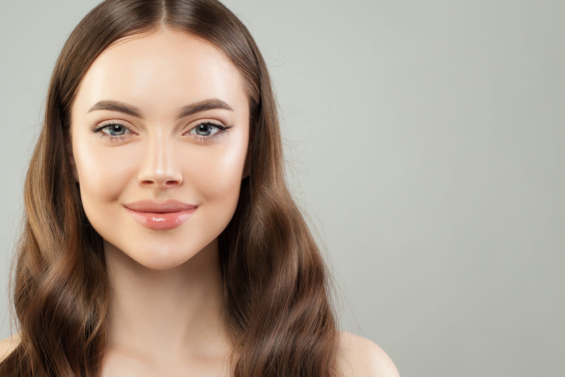 A woman with long hair is smiling and looking at the camera.