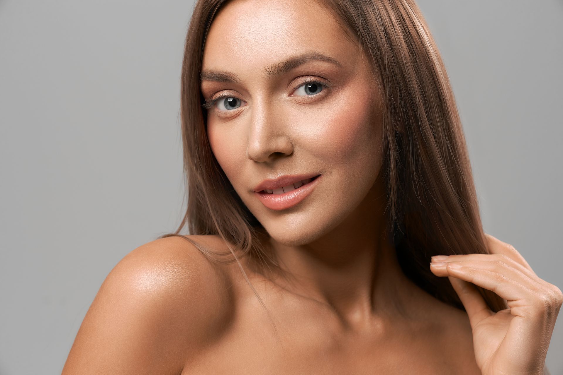 a close up of a woman 's face with her hand on her chin .