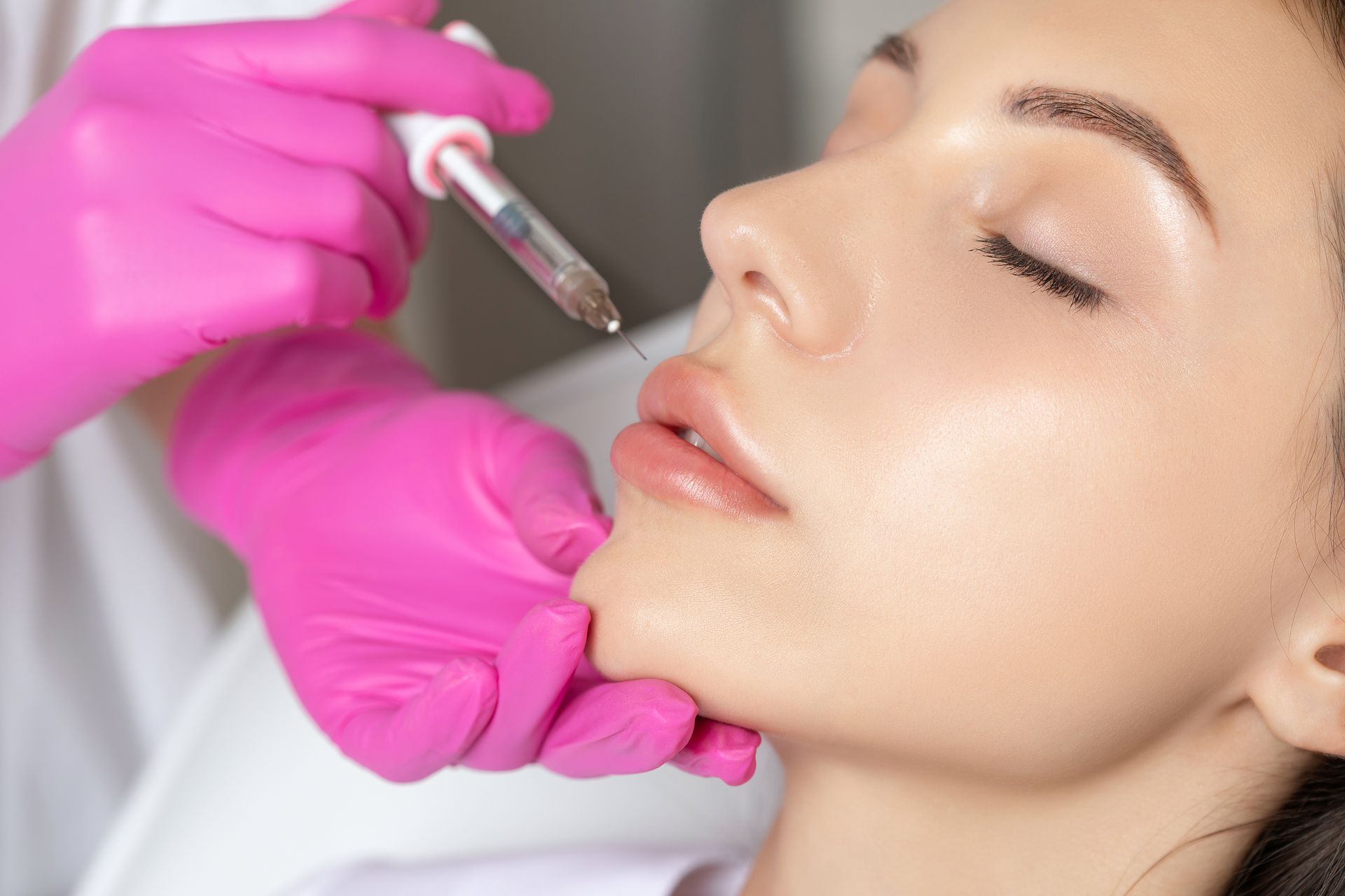 a woman is getting a botox injection in her lips .