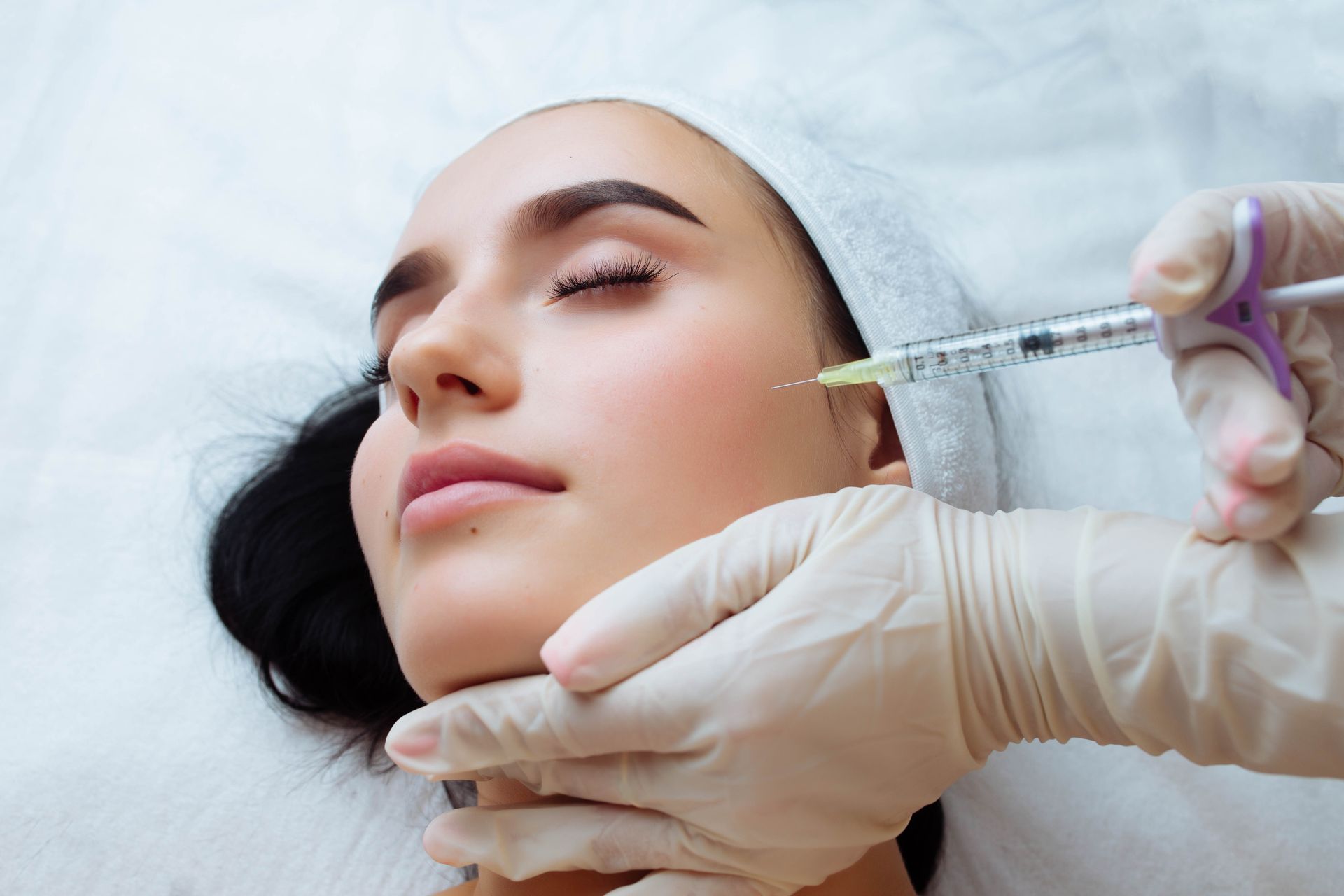 a woman is getting an injection in her face .
