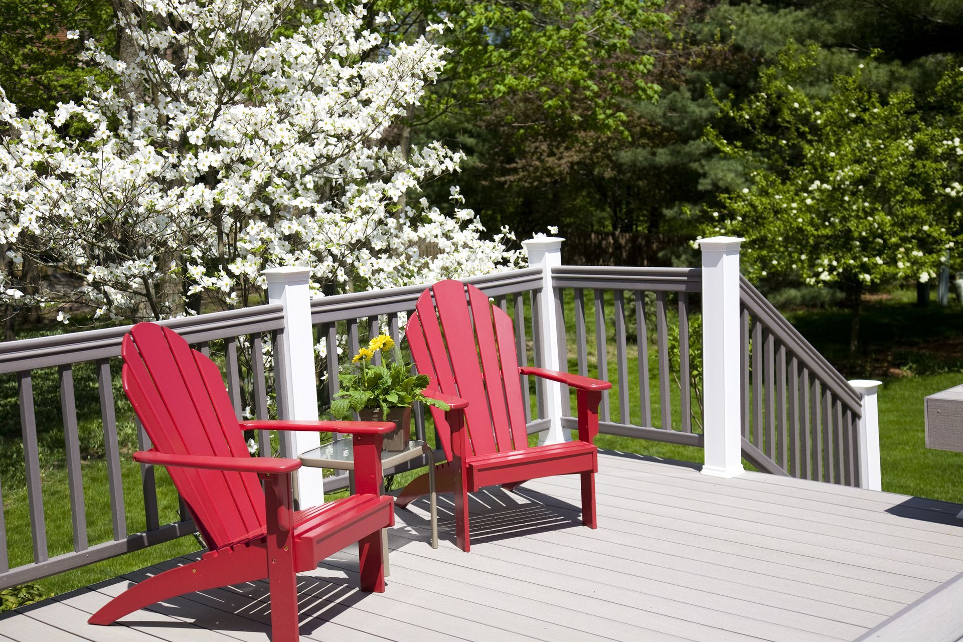Two red adirondack chairs are sitting on a deck