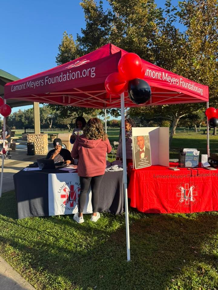 Event tent for Edmond Meyers Foundation with people and tables outdoors.