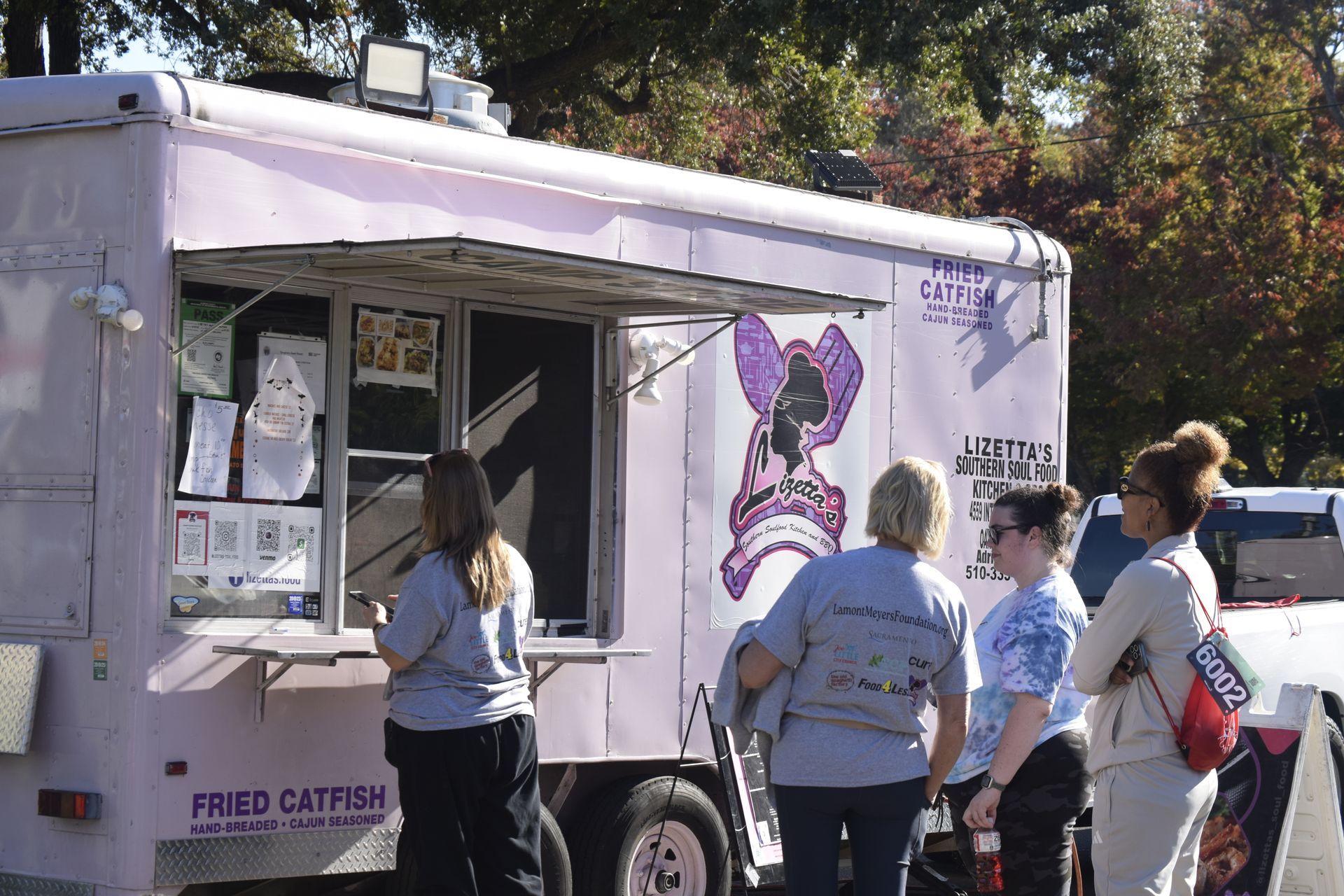Pink food truck with customers, 
