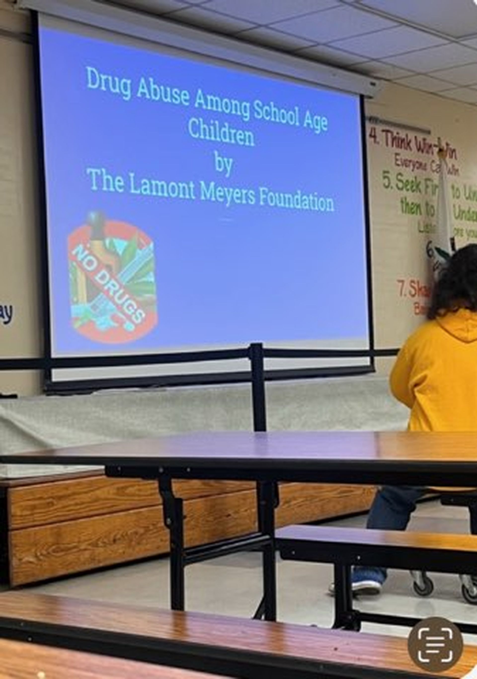 Presentation on drug abuse in a school setting. A screen shows the title and a 