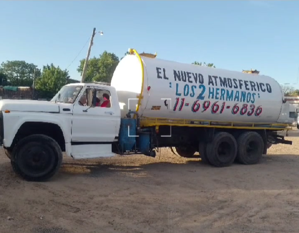 Camión cisterna blanco con detalles en azul, el texto en el tanque dice 