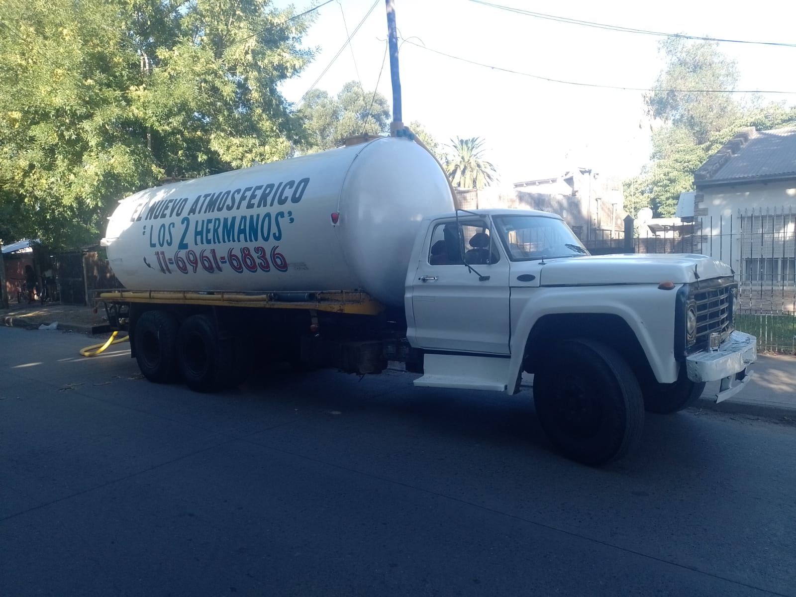Camión cisterna blanco estacionado en una calle; 