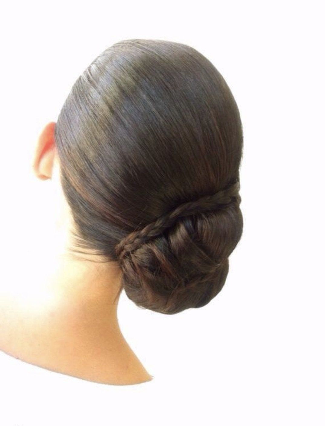 Una mujer lleva el pelo recogido en un moño.