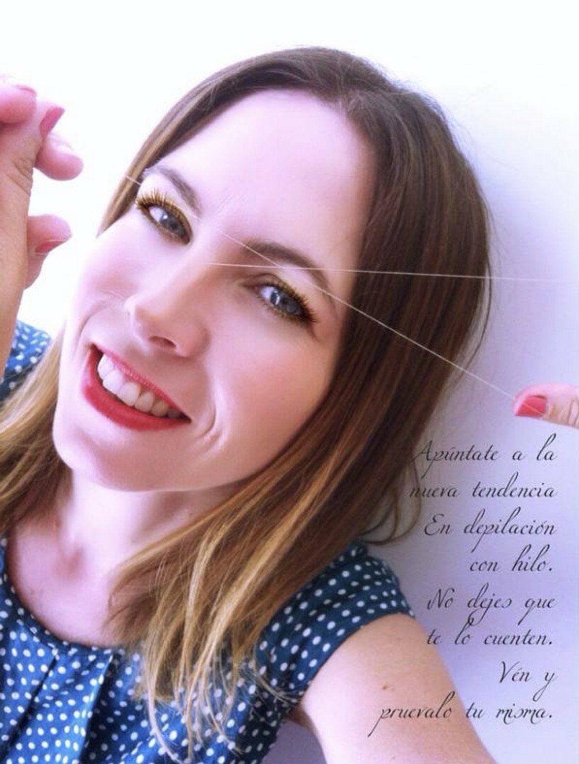 Una mujer con un vestido de lunares azules y blancos está sonriendo.