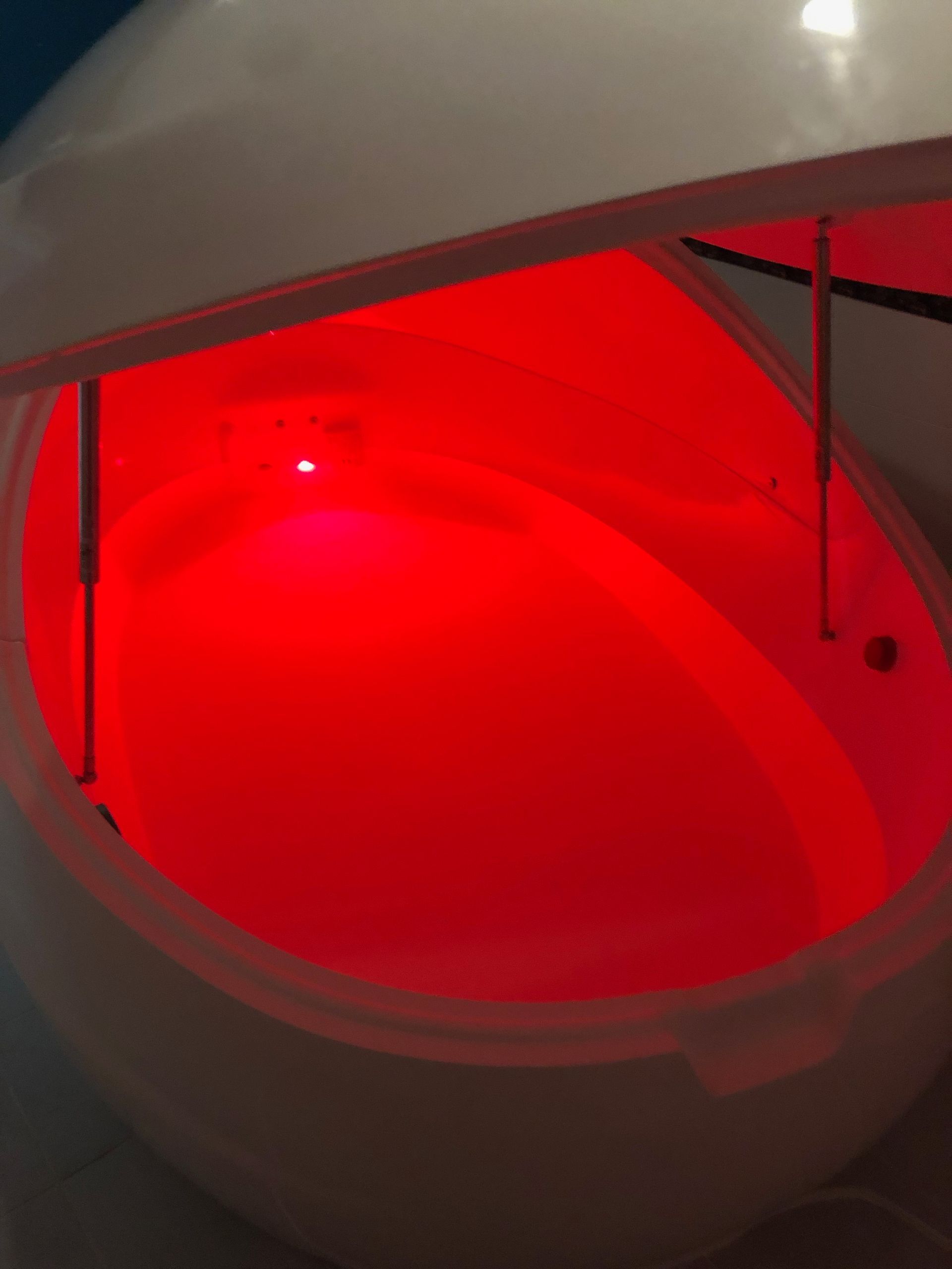 A float tank with red lights on the inside of it.