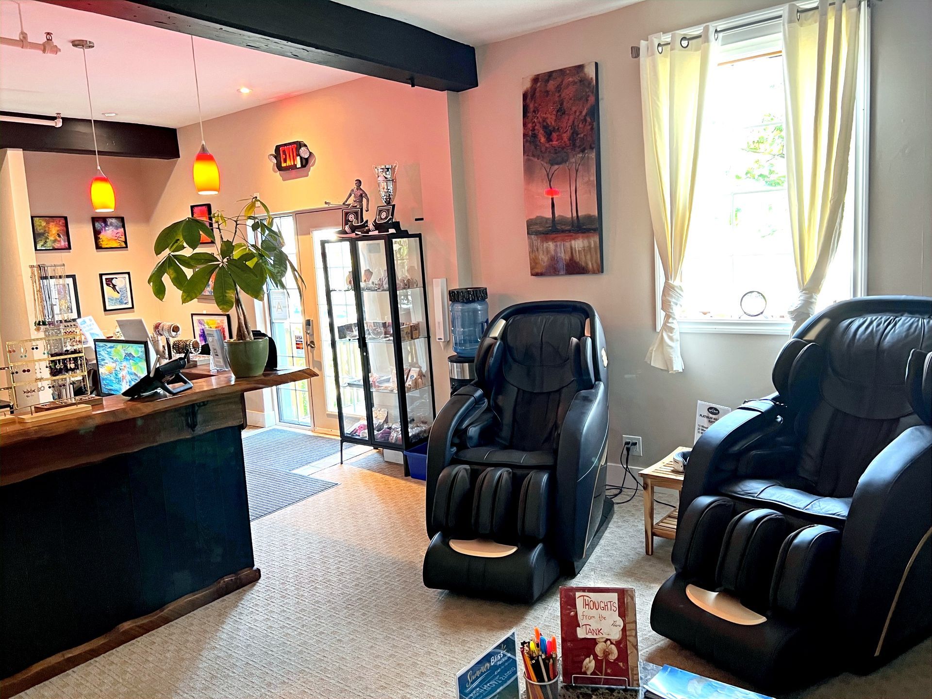 A living room with two massage chairs and a counter.