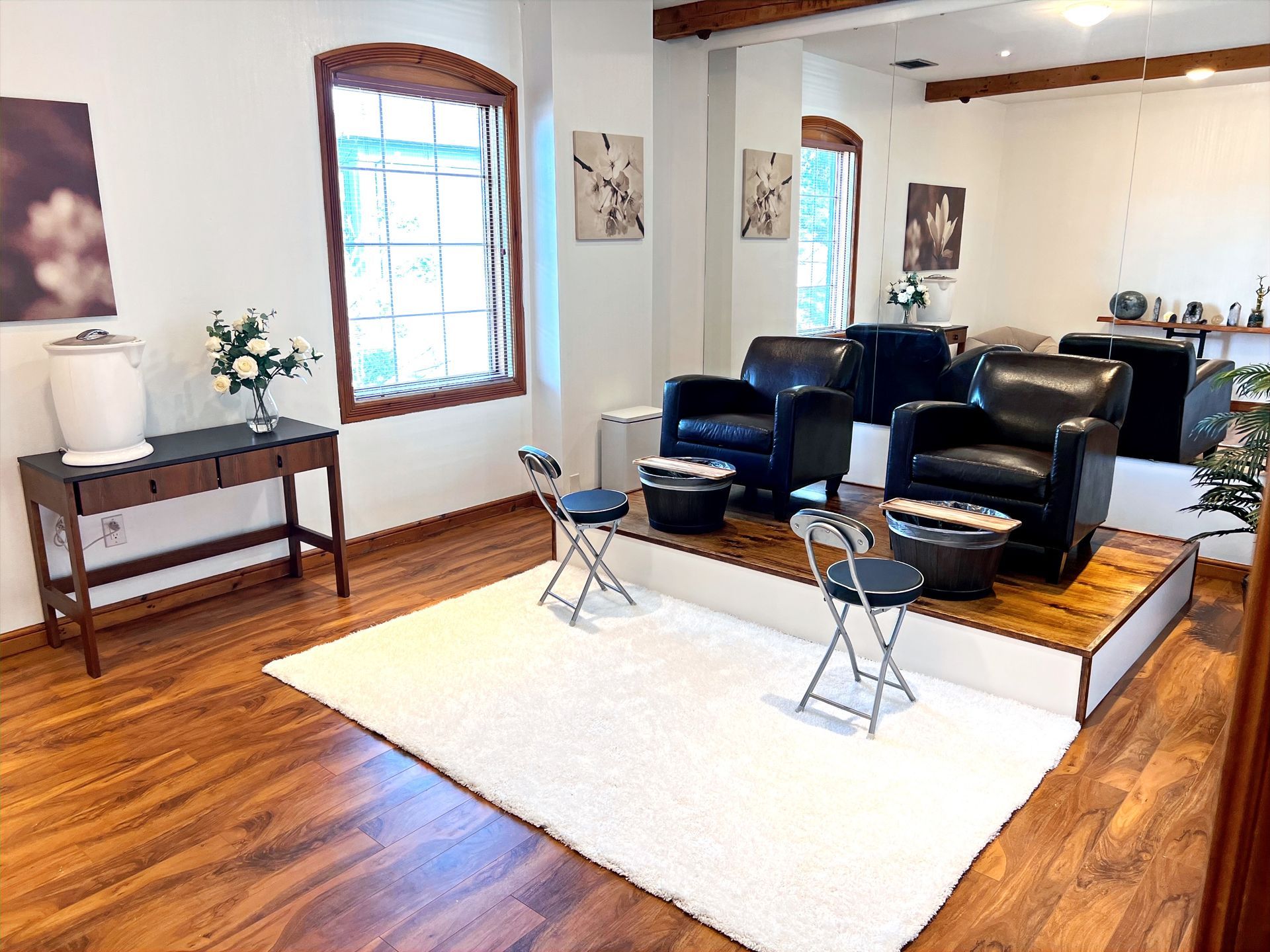 A living room with hardwood floors , chairs , a table and a rug.