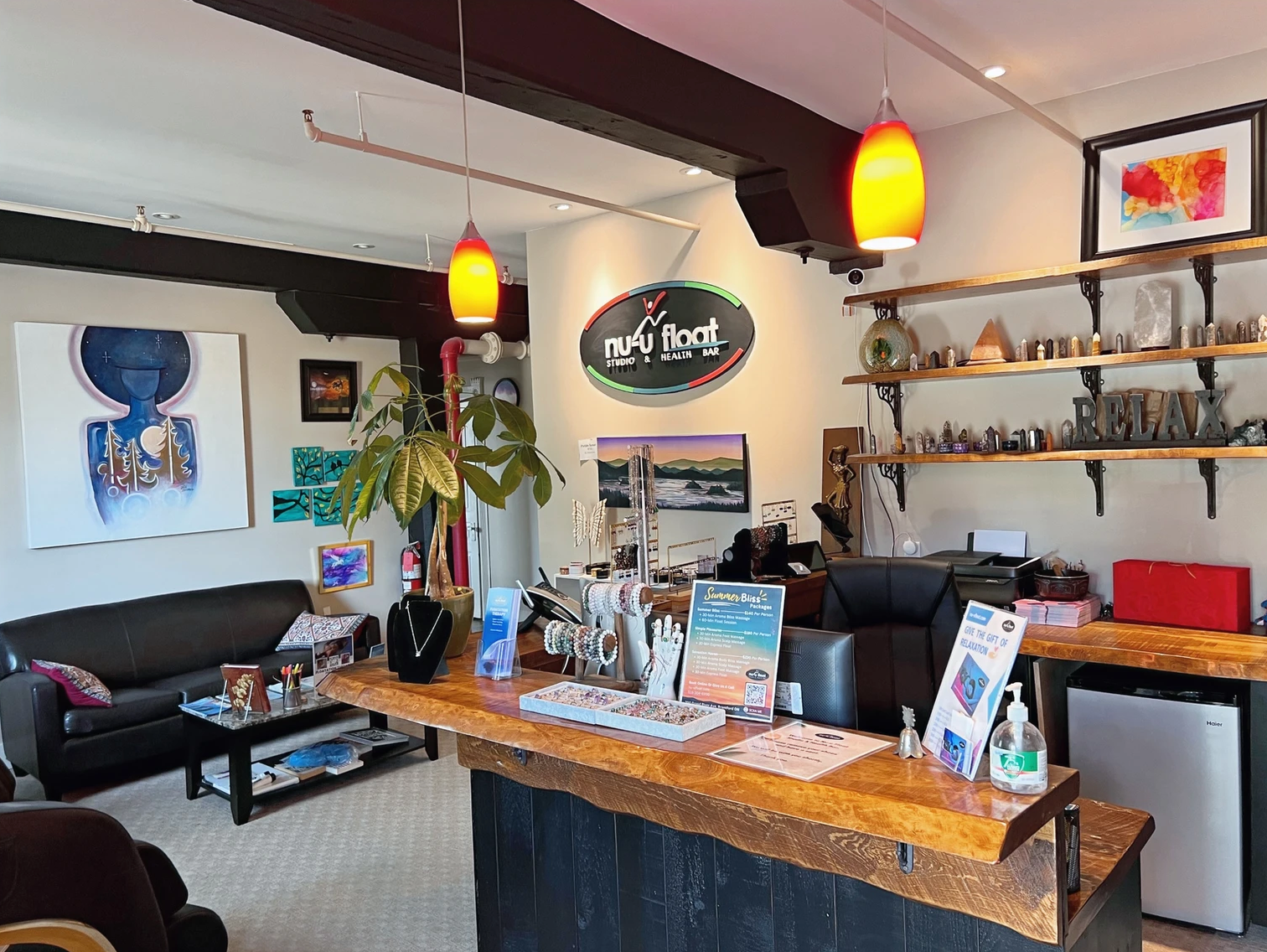 A living room with a couch , table , chairs and a sign on the wall.