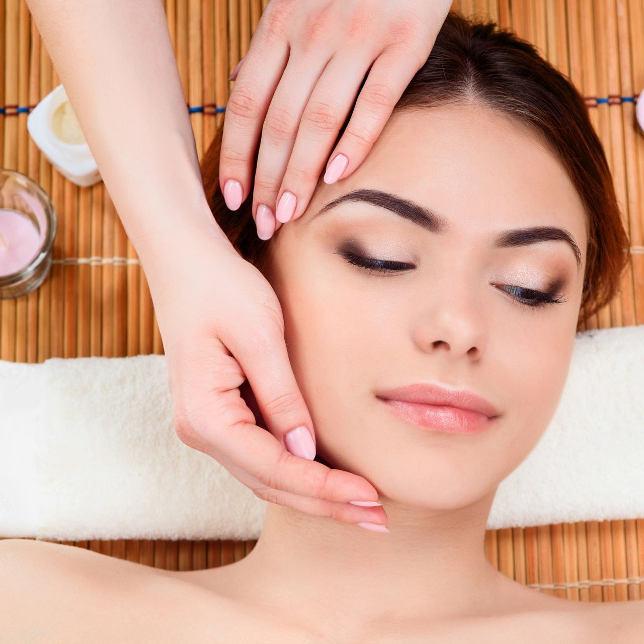 A woman is getting a face massage at a spa.