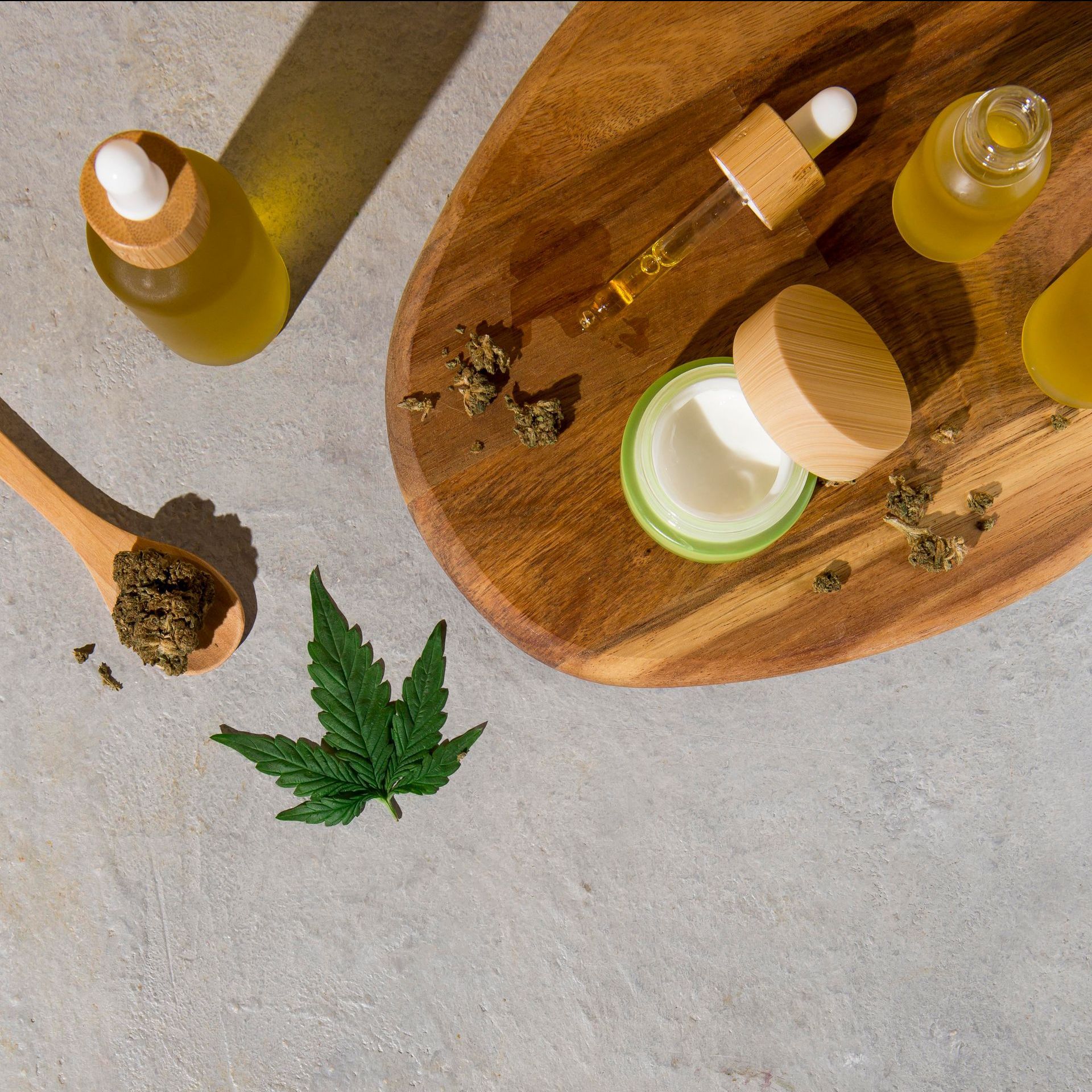 a wooden tray with cbd oil and cream with cannabis leaves