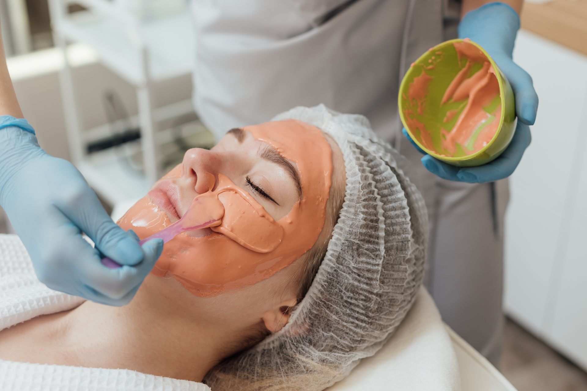 A woman is getting a facial treatment at a spa.