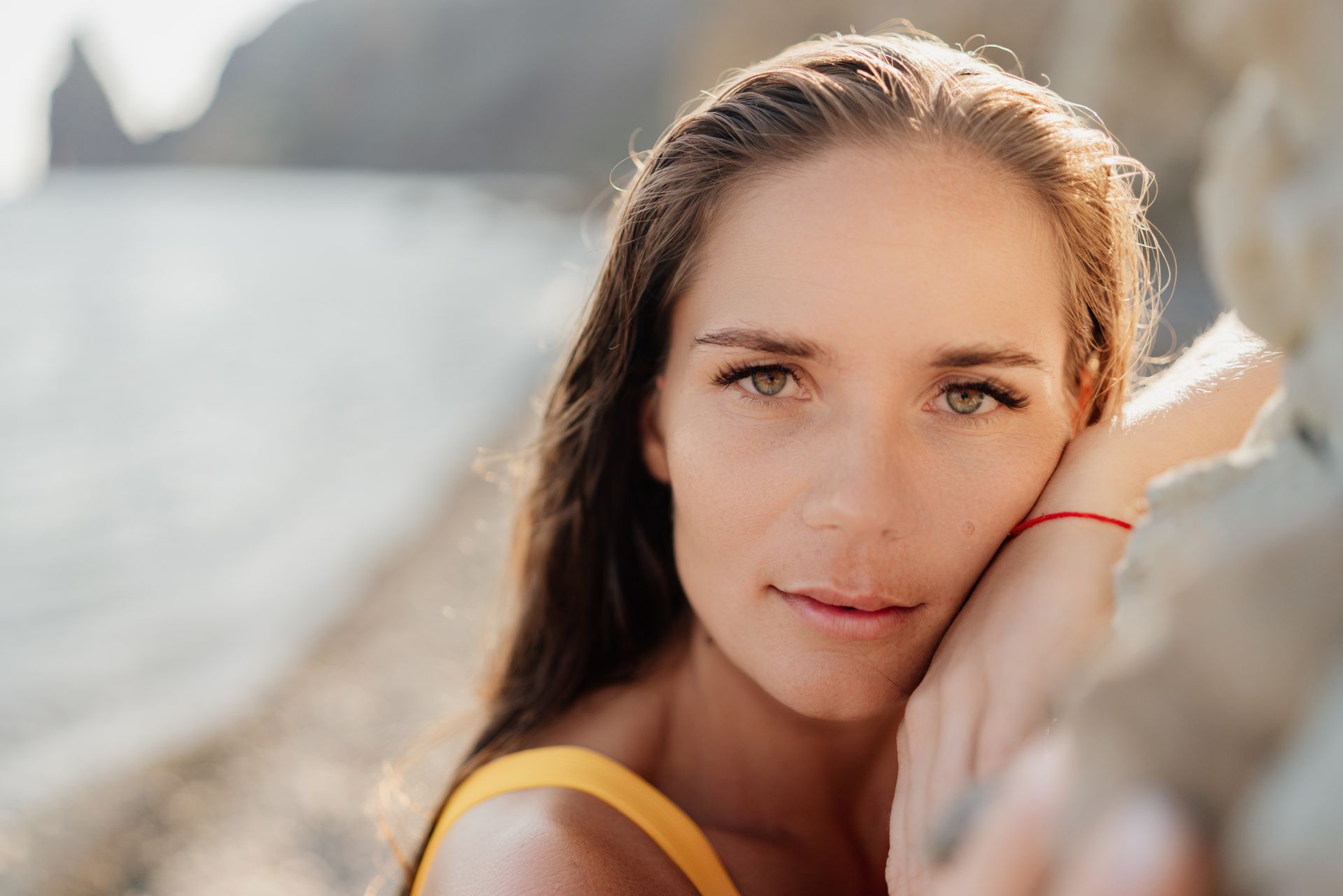 A close up of a woman 's face with her hand on her face.