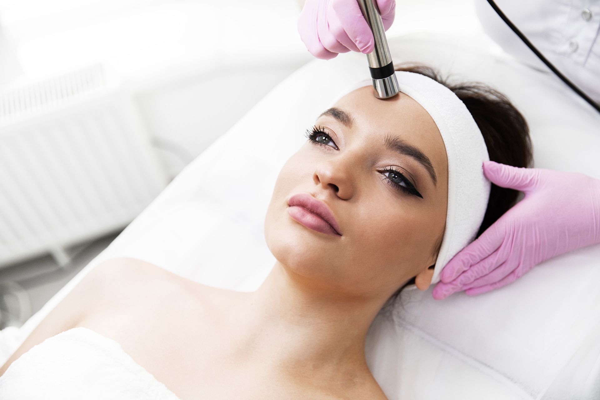 A woman is getting a facial treatment at a beauty salon.