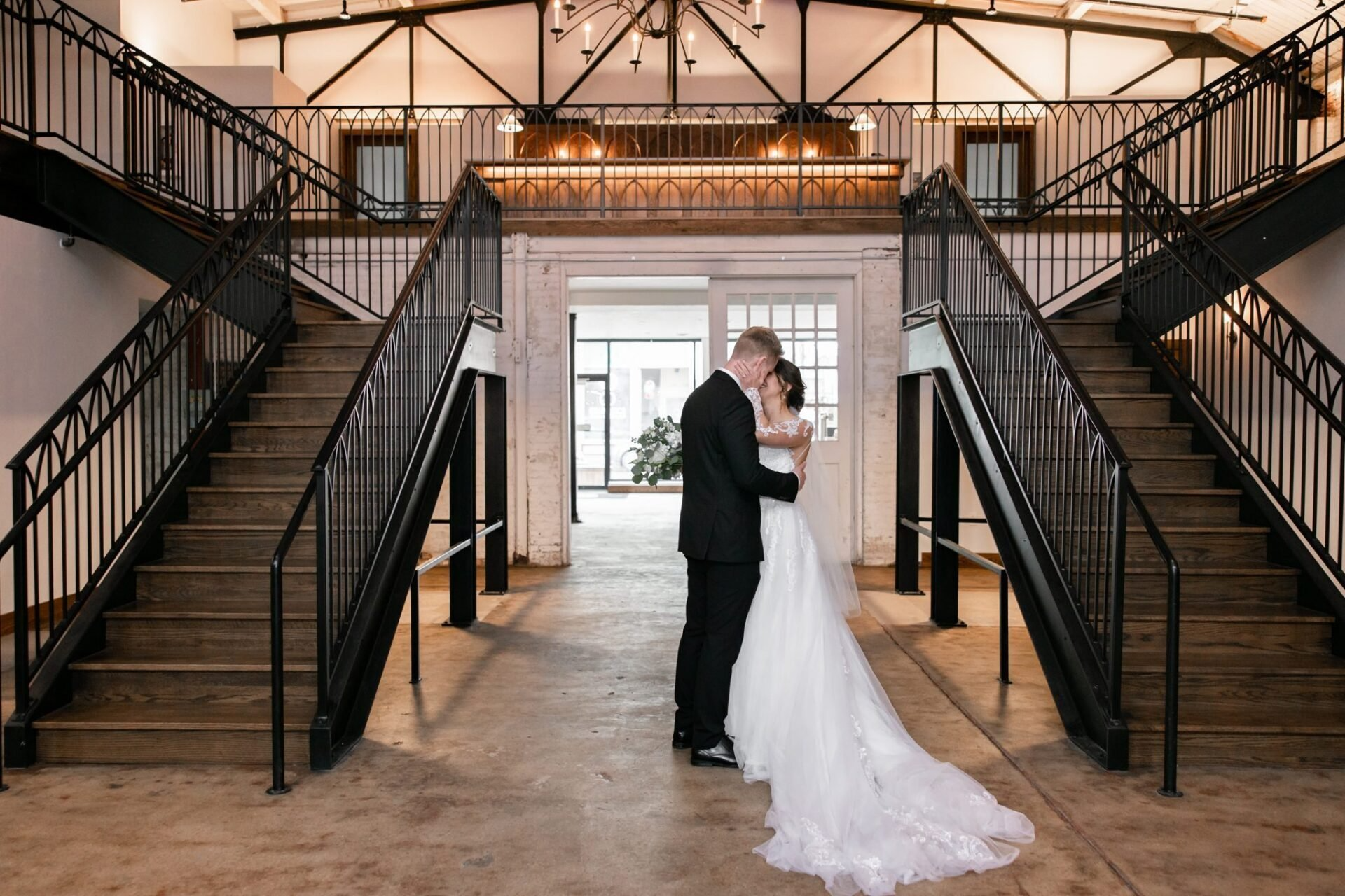 a bride and groom are kissing on a set of stairs